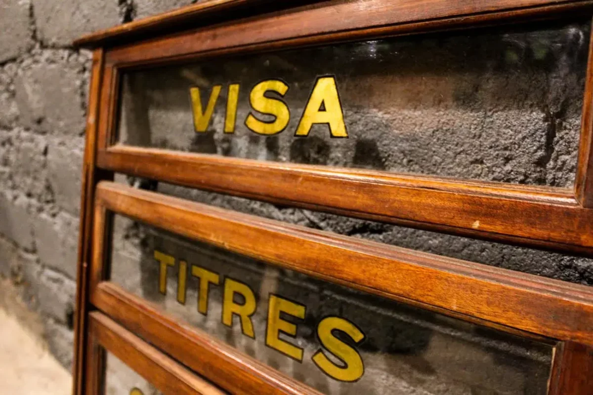 Guichet vitré de transaction en bois, détail des inscriptions dorées.