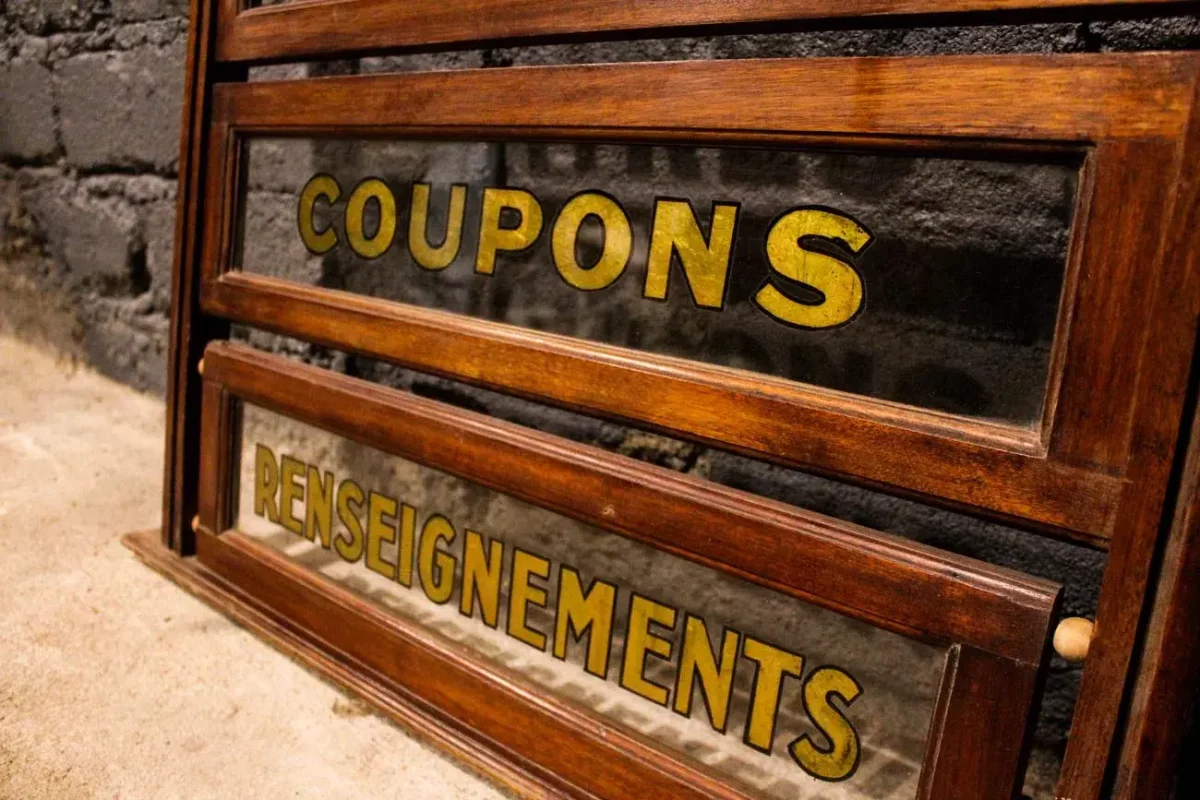 Présentoir commercial vintage, vue rapprochée des vitres et des lettres d'or.