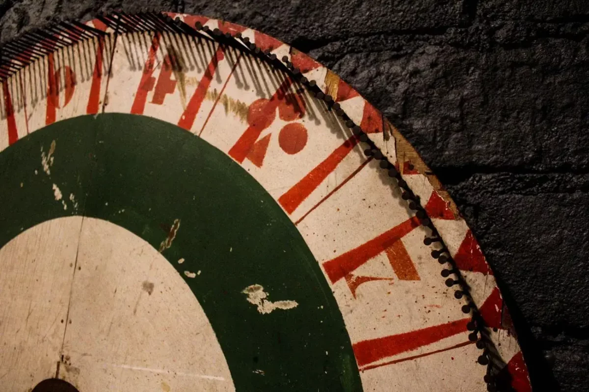 Roue de loterie foraine, gros plan sur numéros et motifs.
