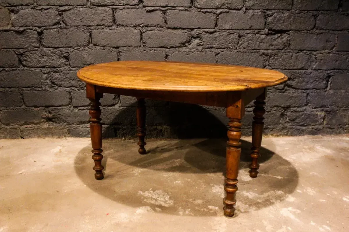 Table ovale à volets en bois massif, pieds tournés, vue d'ensemble.