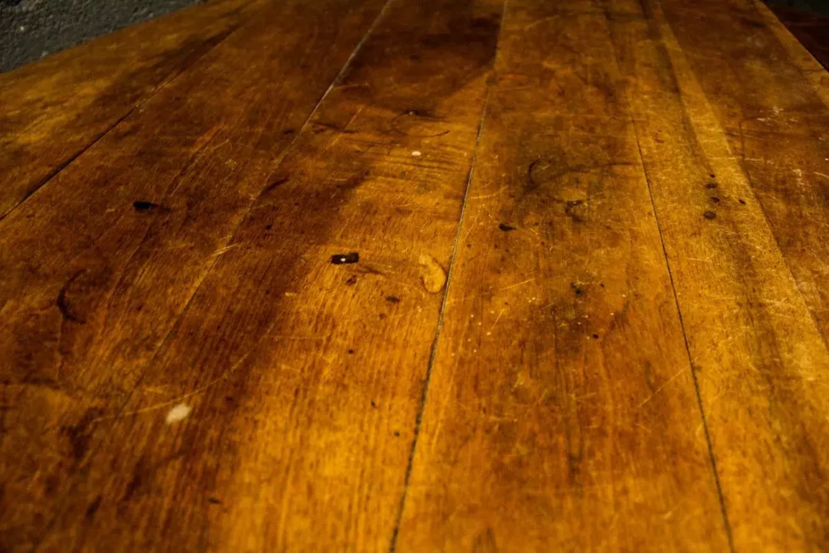 Gros plan sur le plateau en bois massif de la table ovale.
