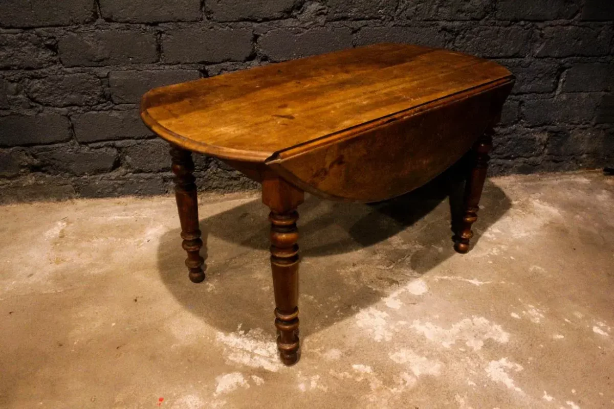 Table ovale à volets fermée, dimensions compactes.