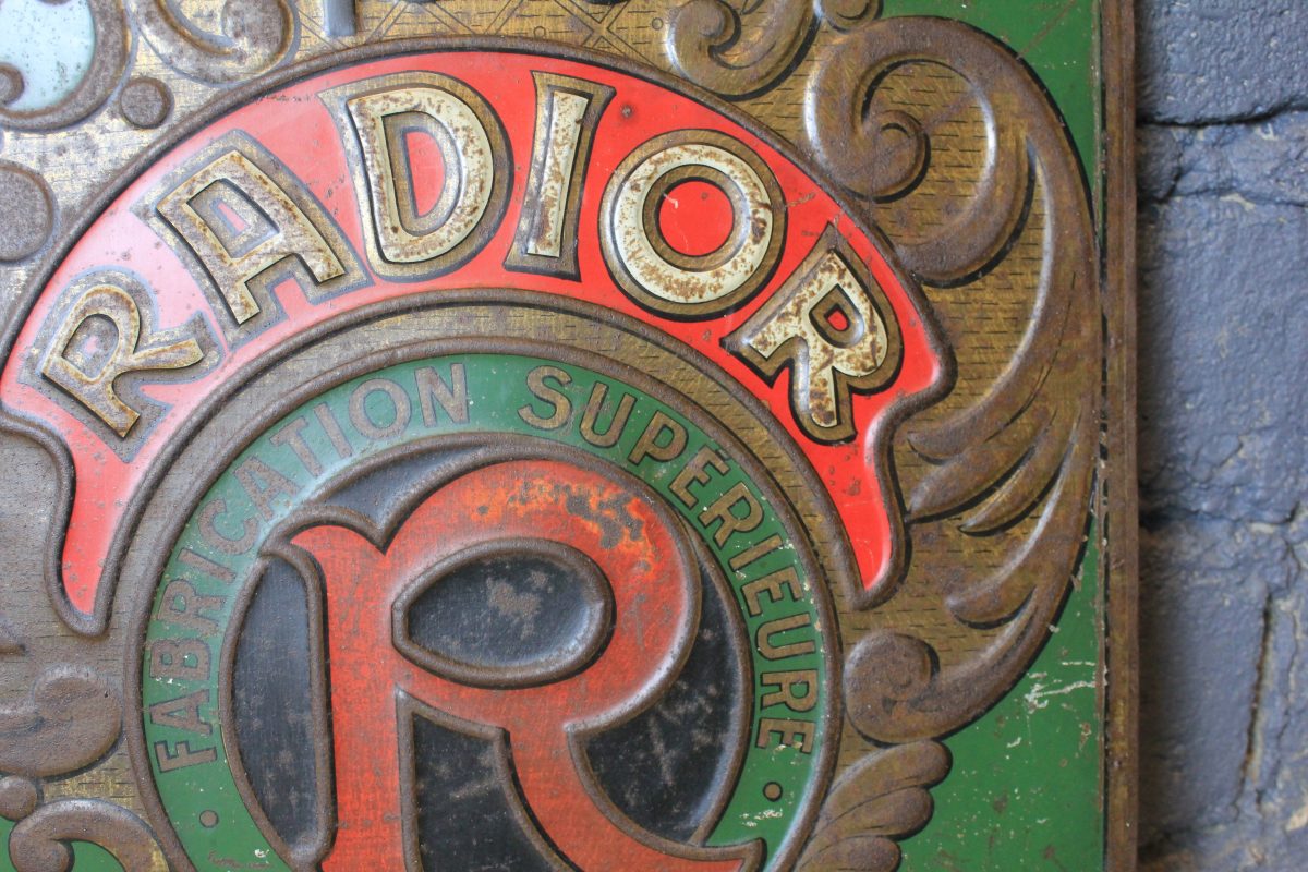 Tôle emboutie publicitaire vintage RADIOR aperçu du centre de la seconde face avec le logo R et la marque RADIOR