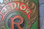 Tôle emboutie publicitaire vintage RADIOR aperçu du centre de la seconde face avec le logo R et la marque RADIOR