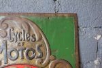 Tôle emboutie publicitaire vintage RADIOR aperçu du coin supérieur droit avec le texte cycles et motos