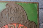 Tôle emboutie publicitaire vintage RADIOR aperçu du coin supérieur droit avec inscription de cycles et motos