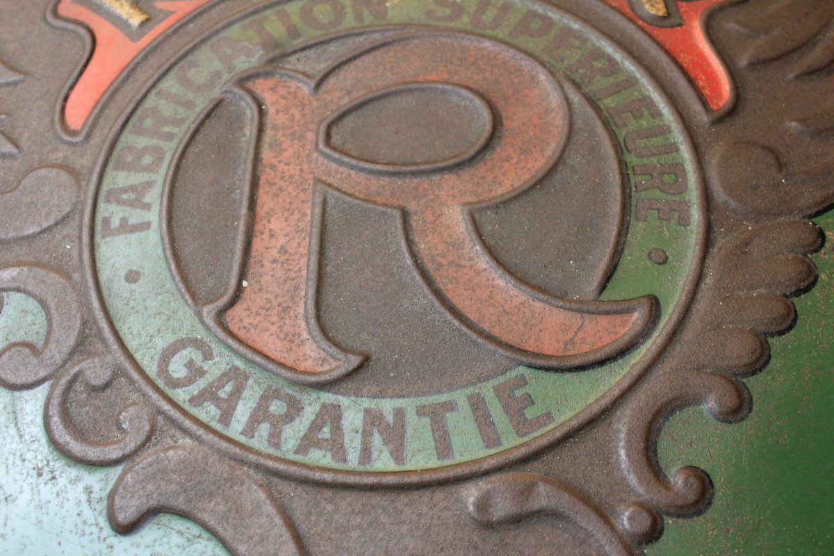 Tôle emboutie publicitaire vintage RADIOR aperçu du centre de la seconde face avec le logo R de la marque RADIOR