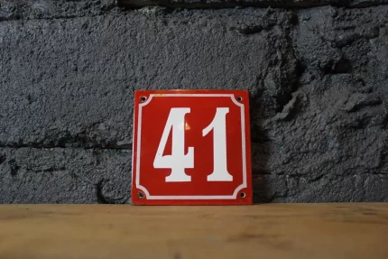 Plaque numérotée 41 émail rouge, chiffre blanc (face).