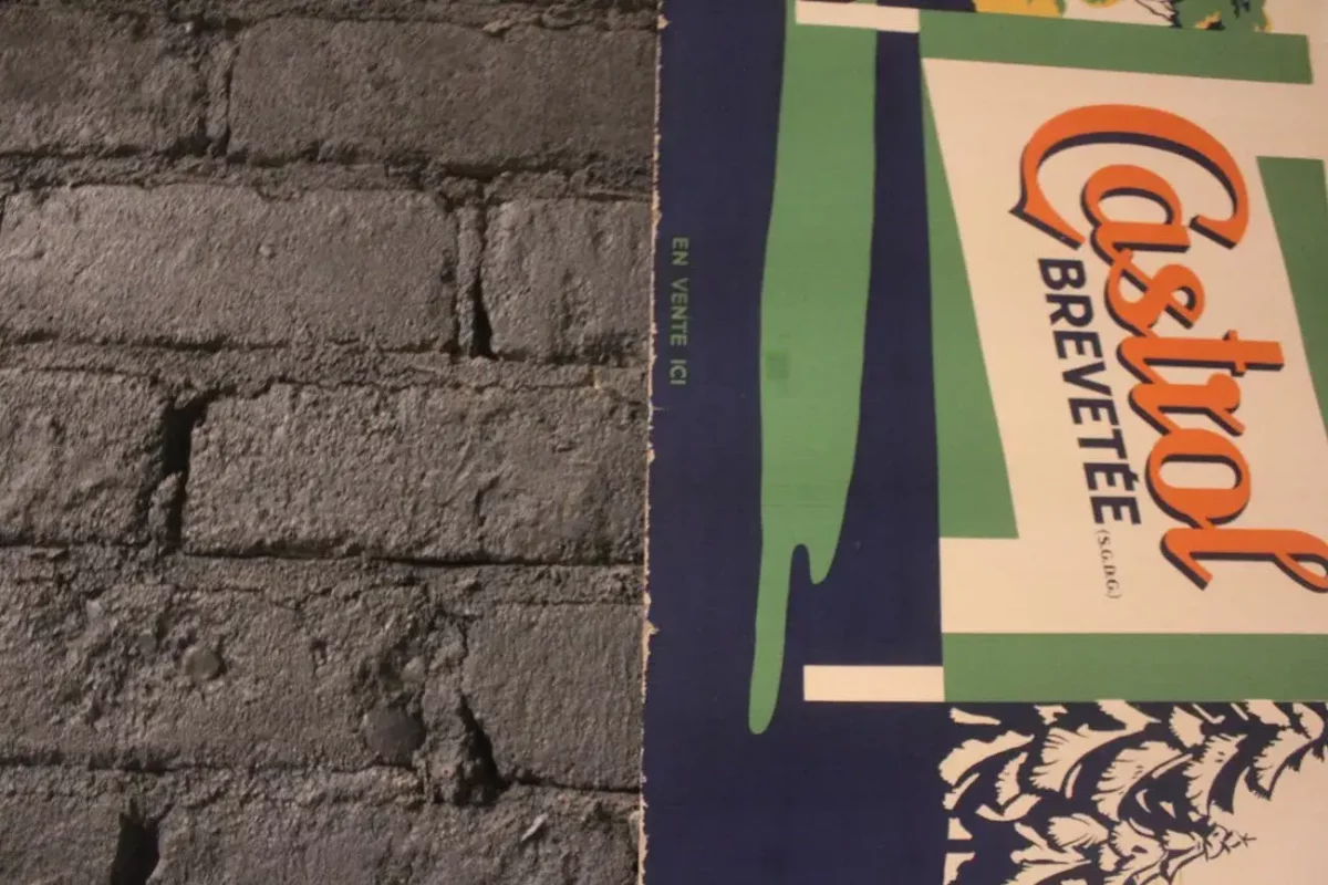 Vue d'ensemble de l'affiche Castrol, défauts d'âge visibles.