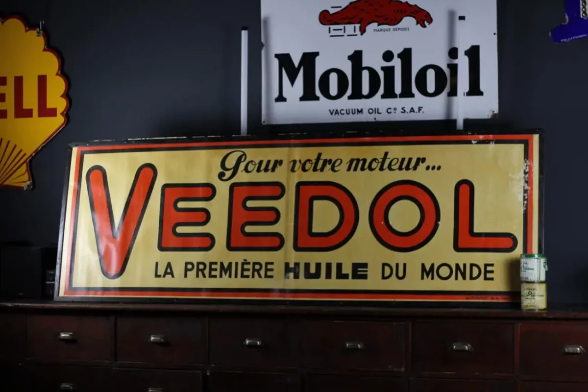 Affiche publicitaire Veedol, couleurs vives et design vintage.