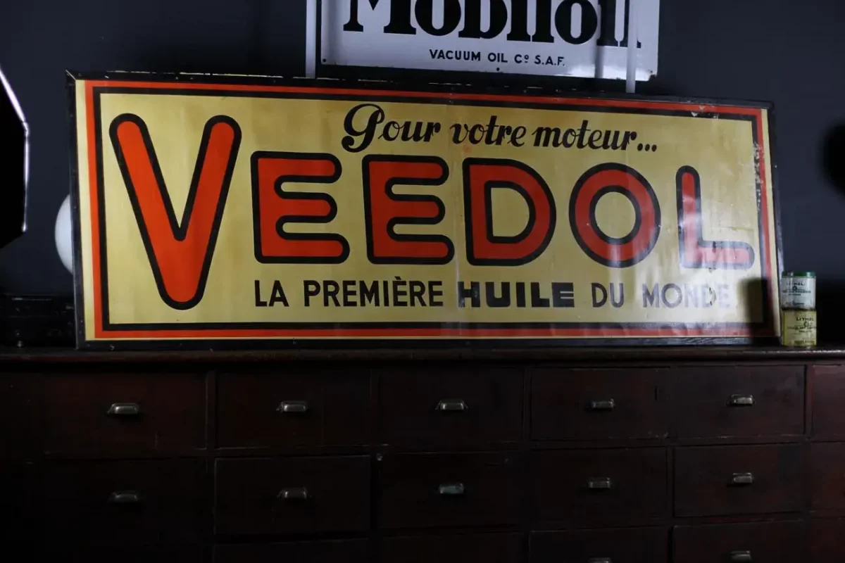 Affiche zinc Veedol, pièce de collection pour amateurs de publicité ancienne.
