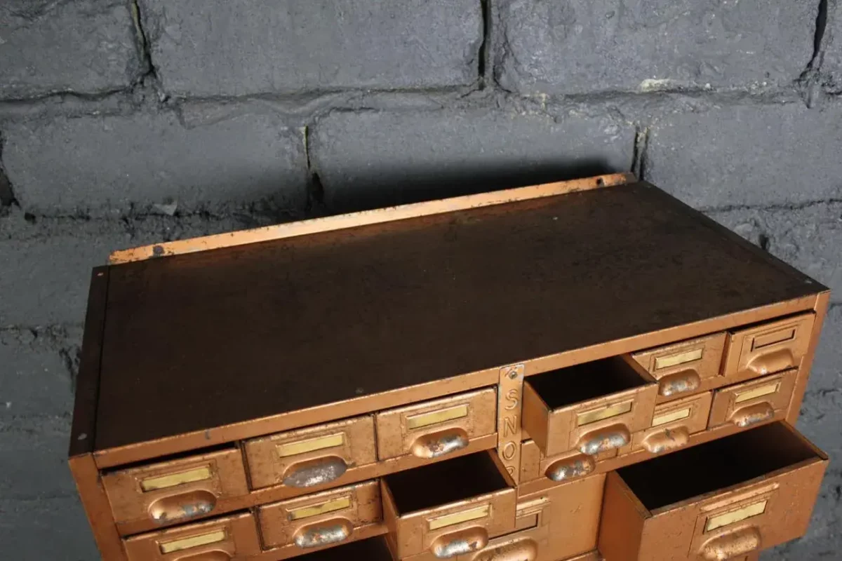 Détail des tiroirs du meuble SNOR, poignées métalliques.
