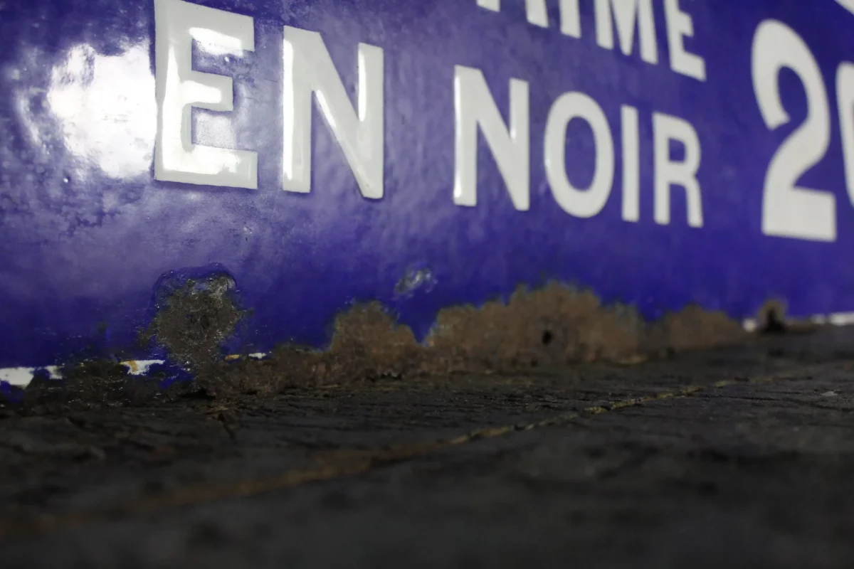 Détail de l'inscription "Imprime en noir" sur la plaque.