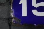 Détail de l'émail épais et des bordures abîmées de la plaque.