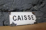 Plaque émaillée "CAISSE", détails et défauts d'angle.