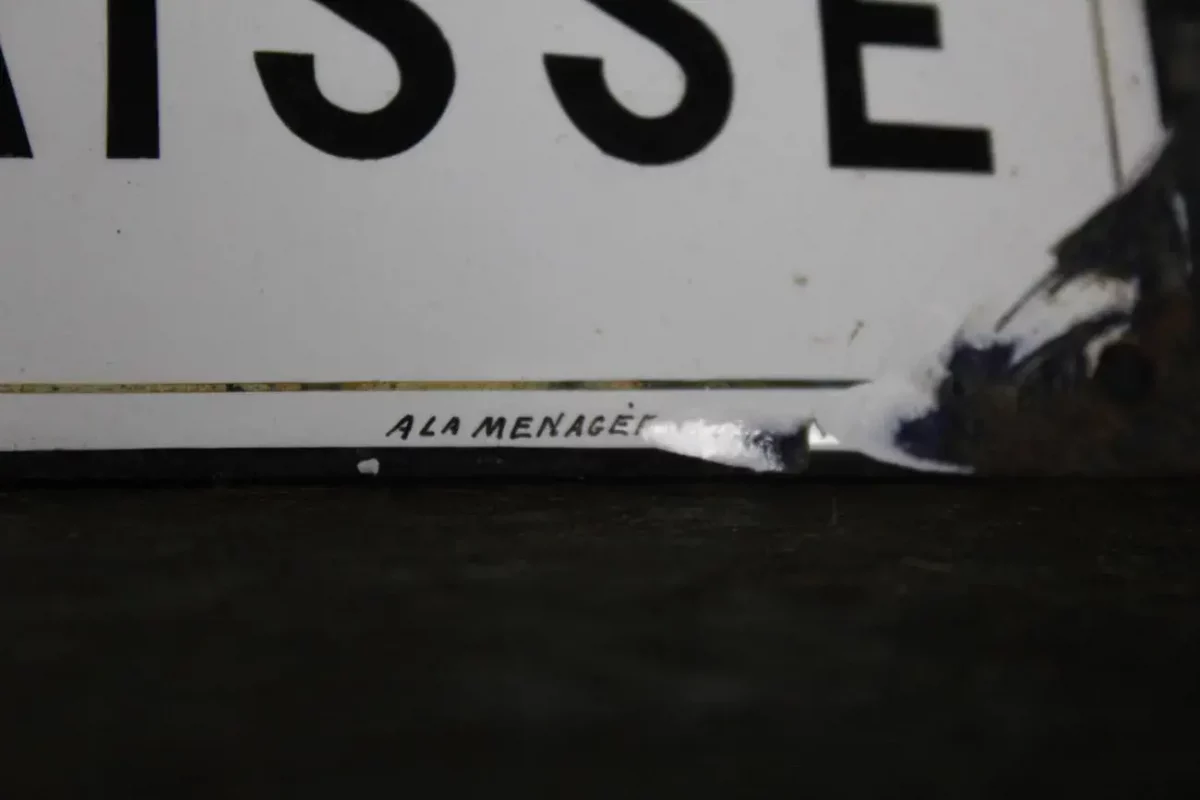 Signature "la ménagère" sur la plaque émaillée.